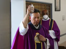 Father Joseph Cao, assisted by Deacon Clarence McDavid, blesses the parts of the church affected by an Aug. 30 break-in, during a Mass of reparation at Curé d'Ars Catholic Church in Denver, Colo., Sept. 1, 2021.